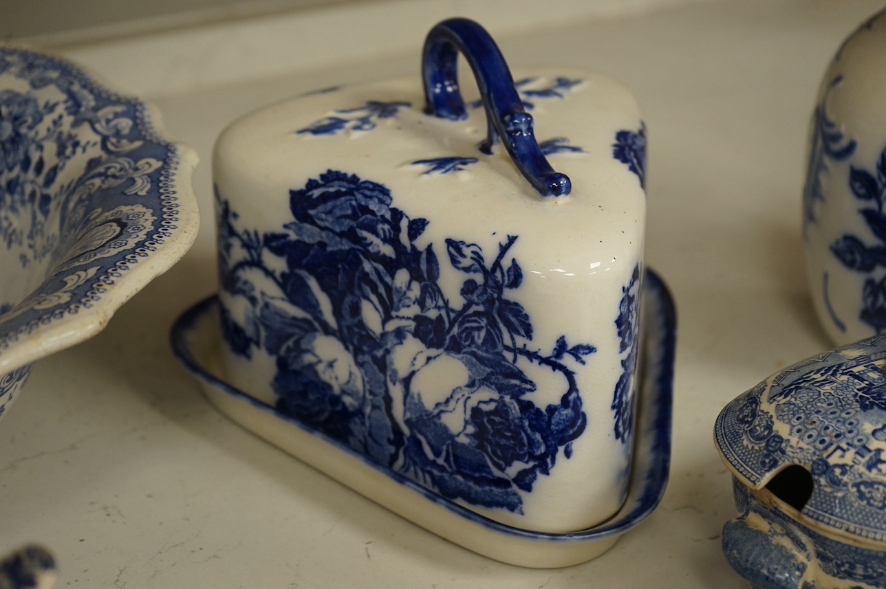 A group of blue and white ceramics to include Ironstone cheese dome and jug, a basin and twin handled cups, largest 36cm in diameter. Condition - varies